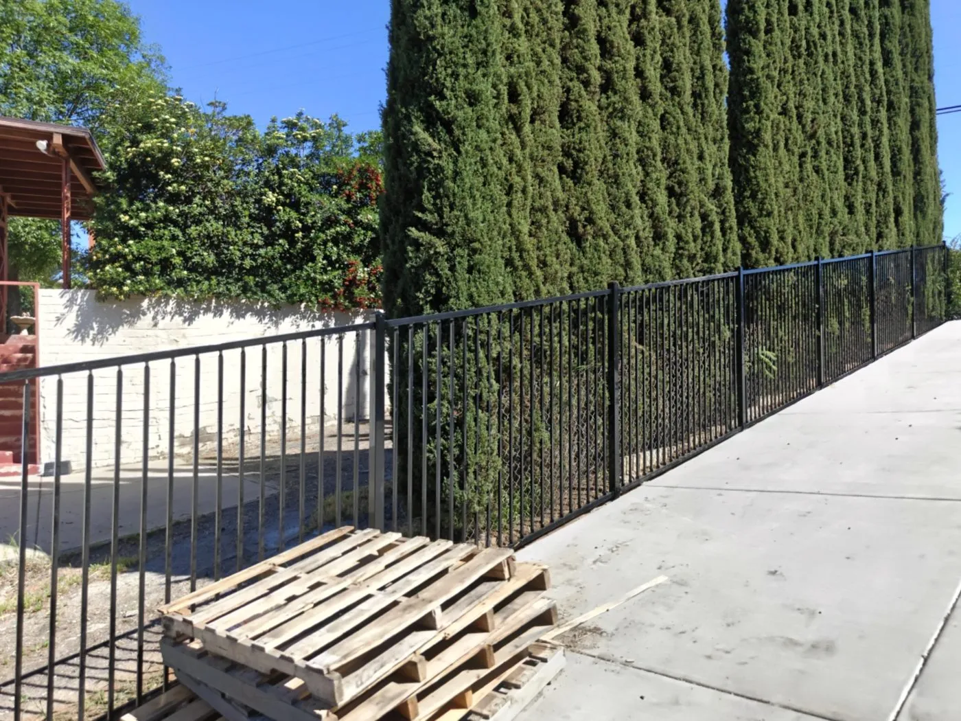 Black wrought iron fence along a driveway