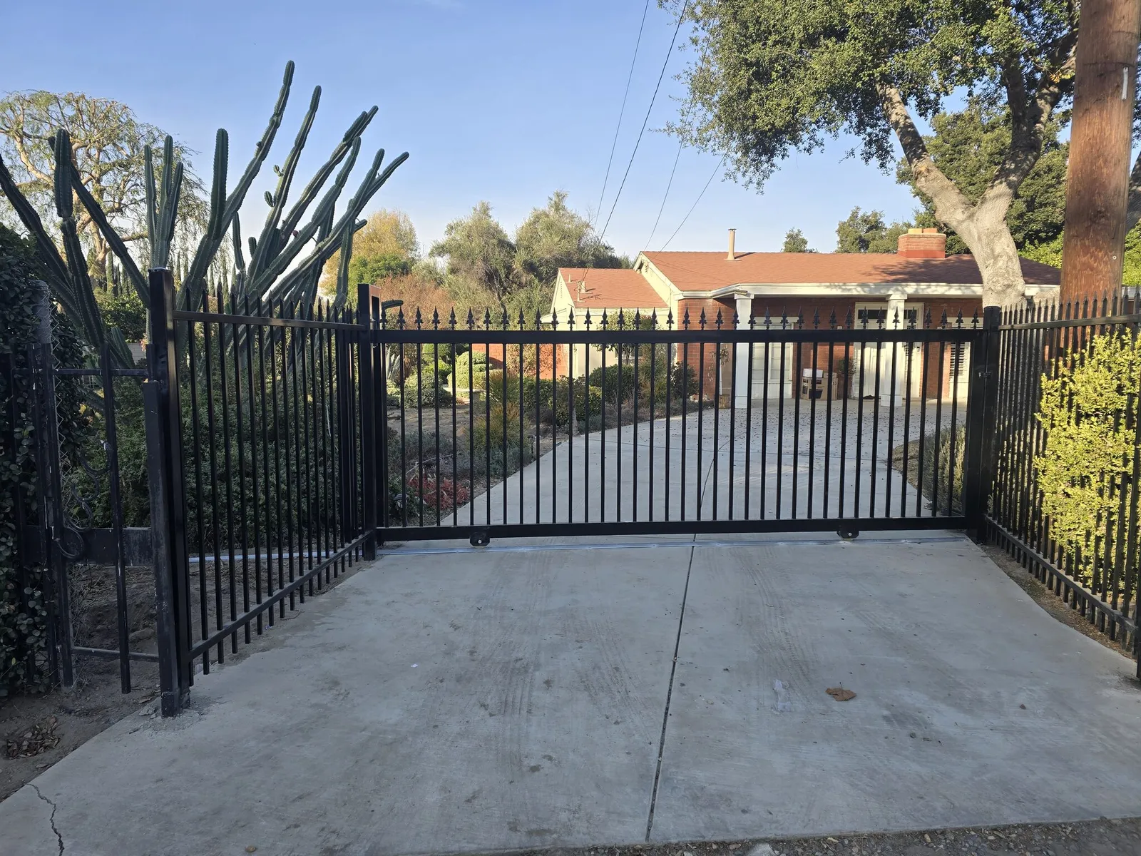 Ornamental iron sliding driveway gate on a larger Southern California lot by Apexguard Fence