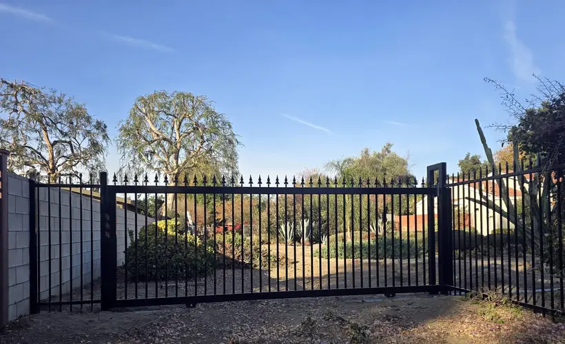 Wrought iron sliding gate and wall-mounted fencing installed in Rosemead, CA by Apexguard Fence