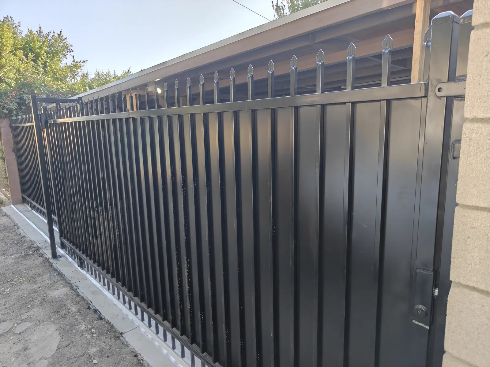 Galvanized powder-coated steel security sliding gate with spear-top pickets for a commercial property by Apexguard Fence