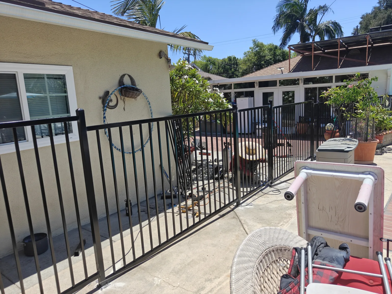 Iron pool safety fence separating a patio from the pool — a real Apexguard Fence project in Ontario, the same build we install in Brea, CA