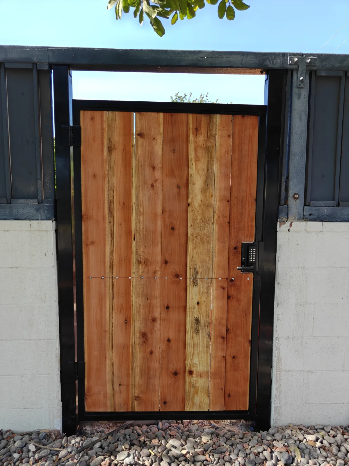 Custom walk gate with black steel frame and redwood infill set in a block wall — a real Apexguard Fence project in Claremont, CA