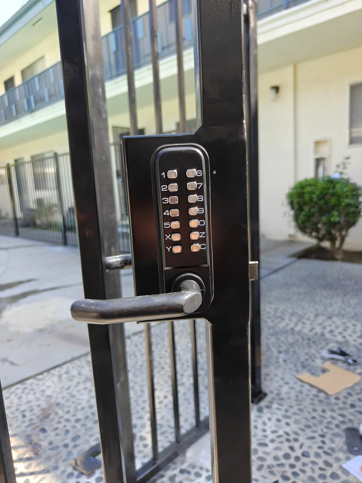 Keypad lock on the black iron pool gate at a West Covina apartment complex by Apexguard Fence