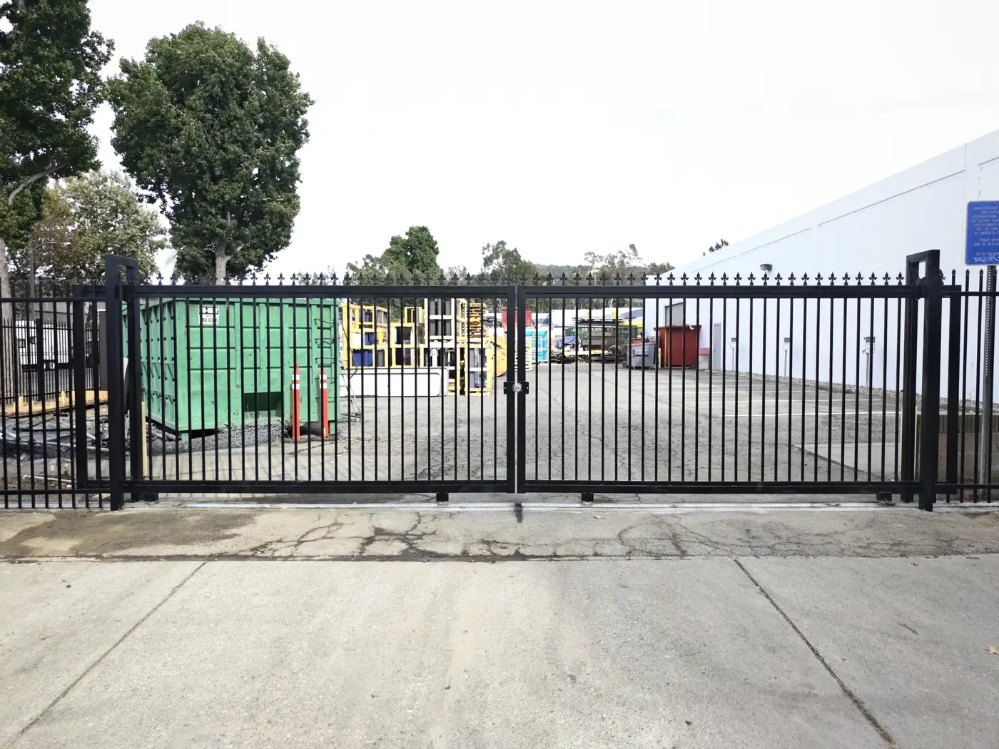 Completed double swing driveway gate closed across a commercial yard entrance in Whittier, CA
