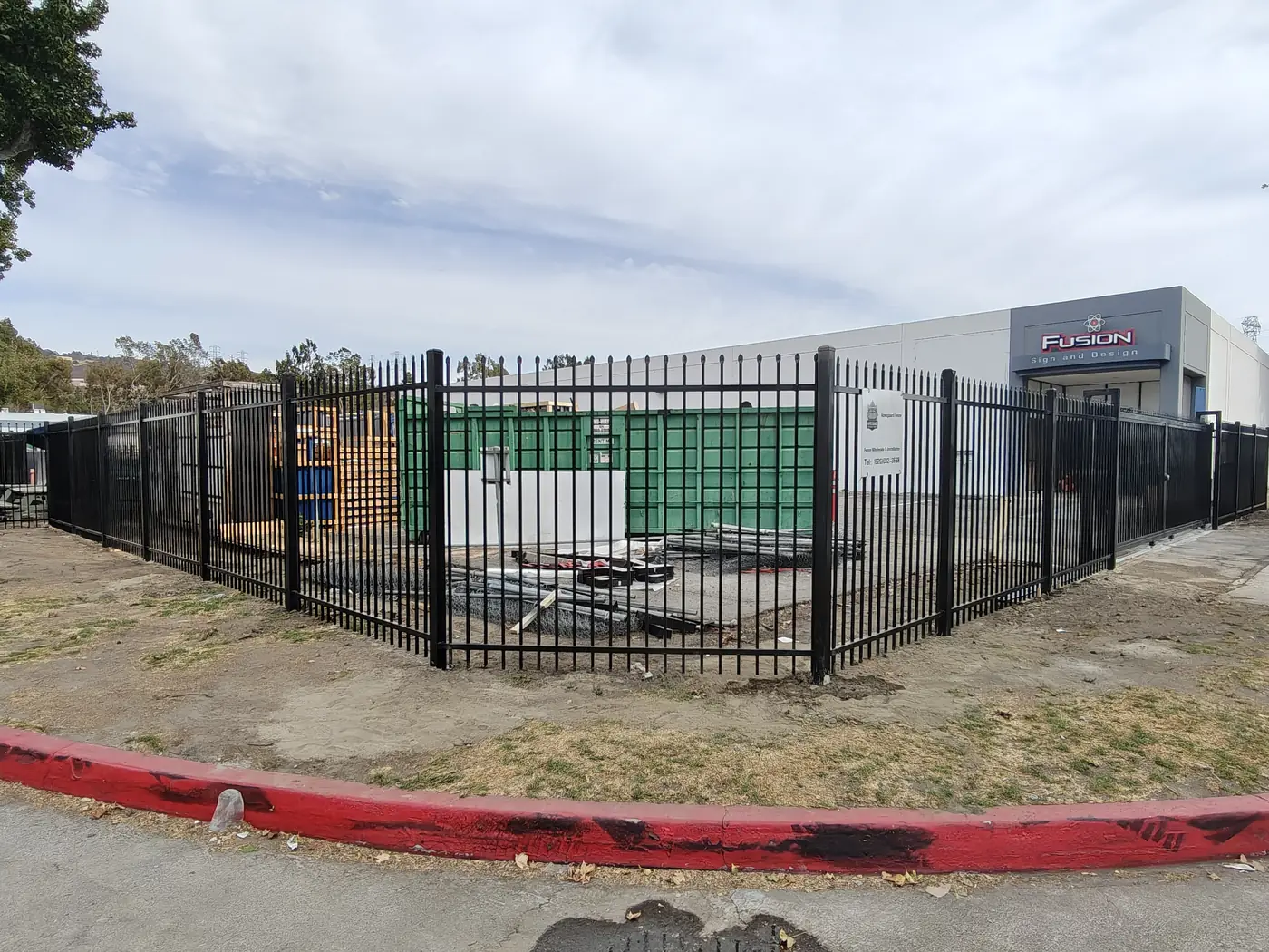 Corner of the completed commercial spike fence with the Apexguard Fence project sign in Whittier, CA