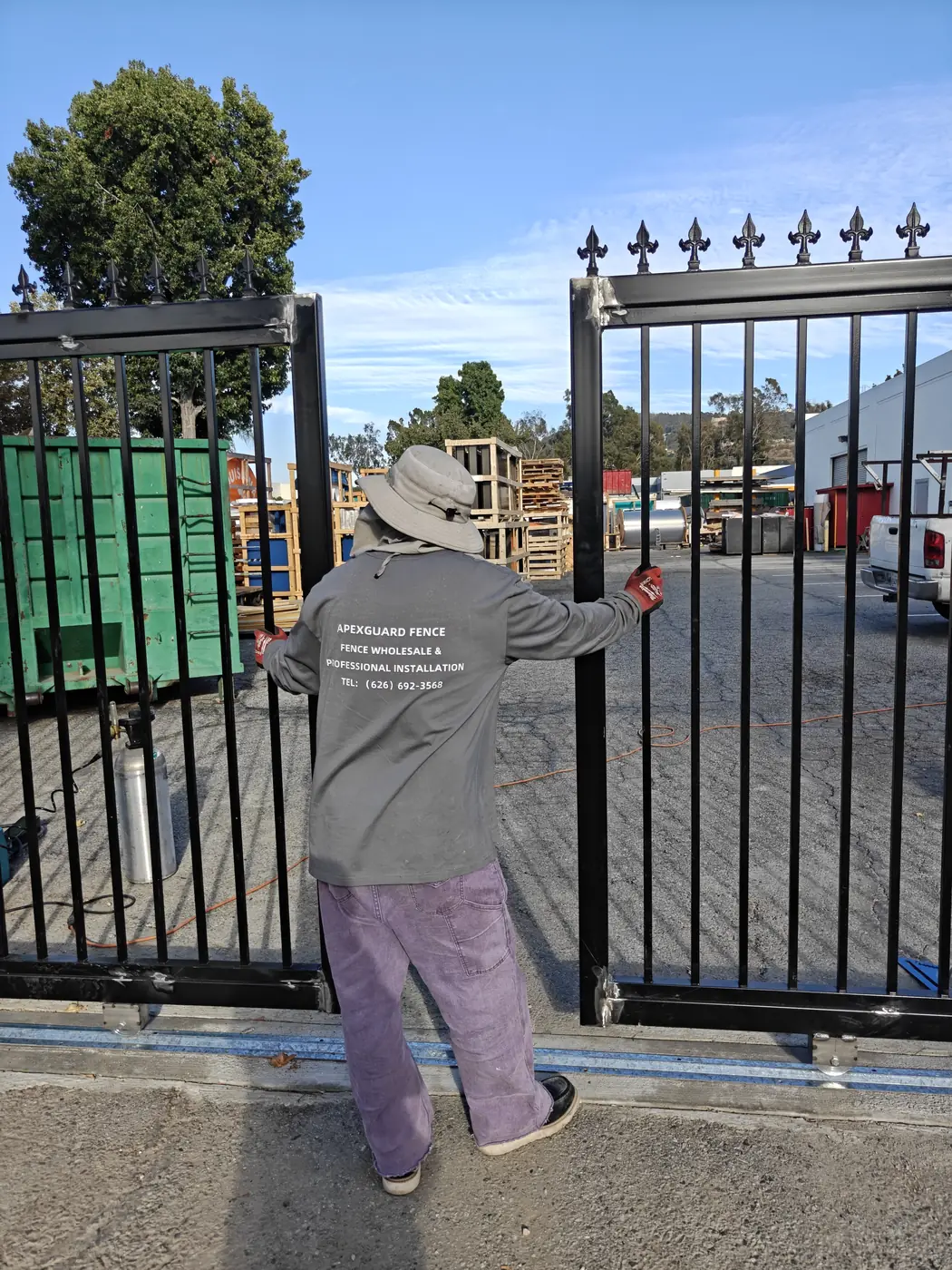 Apexguard Fence installer hanging and aligning a steel double swing gate leaf in Whittier, CA