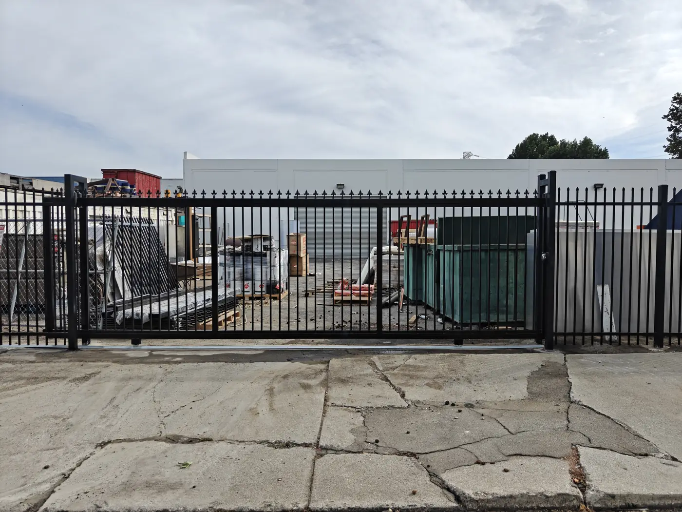 Completed double swing gate and 7 ft spike fence at a commercial driveway entrance in Whittier, CA