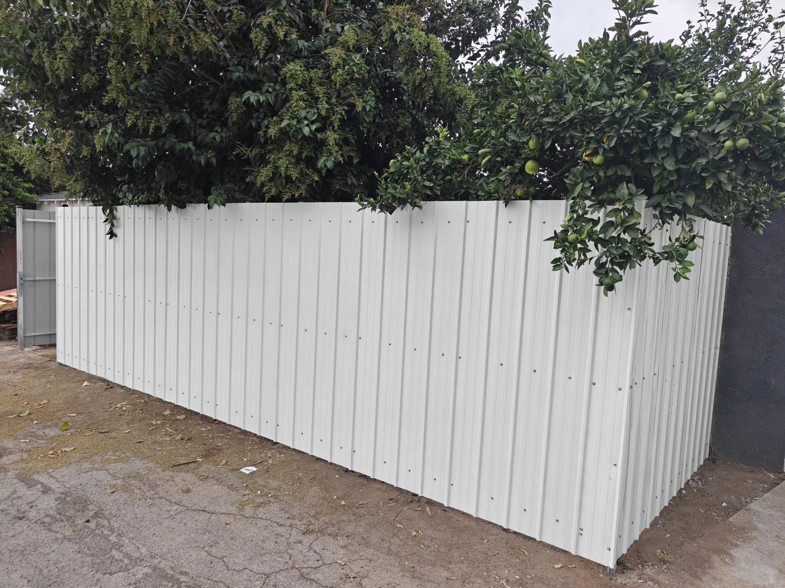 Long run of 7 ft white steel panel privacy fencing seen from the alley in Whittier, CA by Apexguard Fence