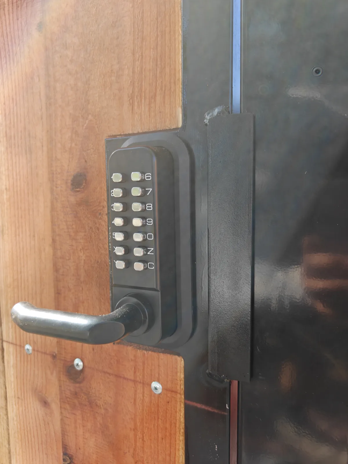 Keypad lock and lever handle detail on a steel-frame wood gate in Claremont, CA by Apexguard Fence
