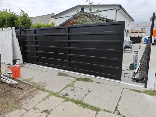 Custom black sliding driveway gate installed by Apexguard Fence